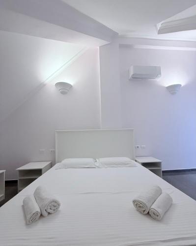 a bedroom with a white bed with two towels on it at Keshtjella Duka in Rrëshen