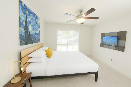a white bedroom with a bed and a ceiling fan at Perfect Location 2BR 5 Min Walk to Galleria Marquee Uptown in Houston