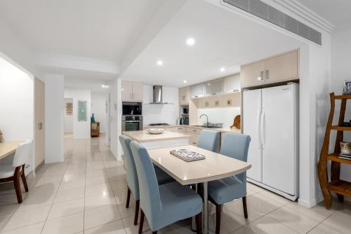 a kitchen and dining room with a table and chairs at Azul at Island Views—Bask in Beachfront Living in Palm Cove