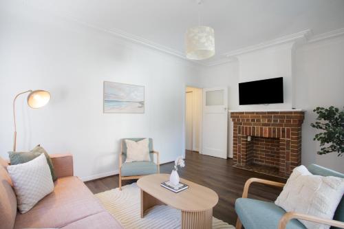 a living room with a couch and a fireplace at 2RB Glebe Retreat Free Parking, Yard & Pet Friendly in Sydney