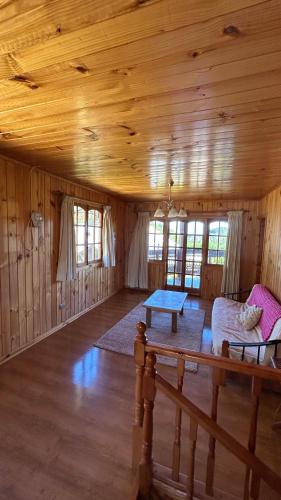 a living room with a couch and a table in a cabin at Hostal Tregualemu in Pelluhue