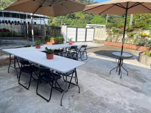 two tables and chairs with umbrellas on a patio at 佳林居 in Dahu