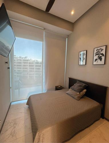 a bedroom with a bed and a large window at Marítima Playa Flamingos Renting 5i Richards in Bucerías