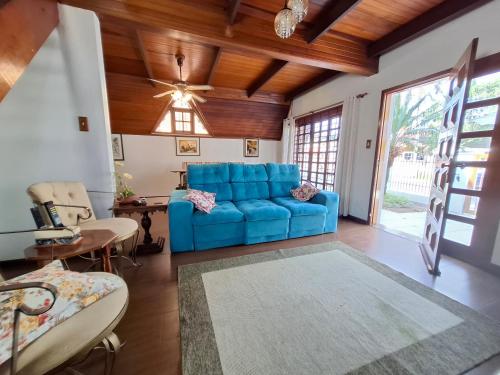 a blue couch in a living room with a ceiling fan at Linda Cabana 3 Quartos a 50m da Praia in São Lourenço do Sul