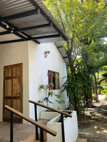 a house with a wooden door and a porch at Akih Pods Hostel in Santa Teresa Beach