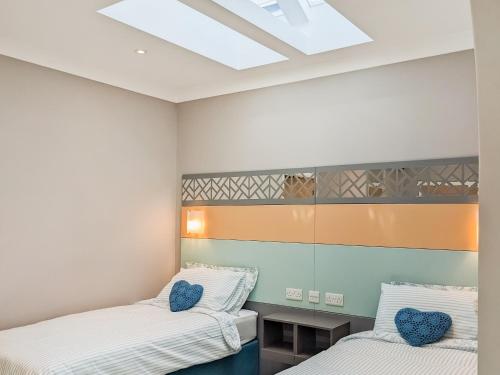 a bedroom with two beds and a skylight at Hogbert's Hideaway in Carlton Colville