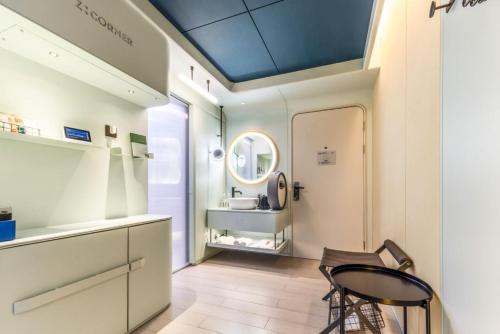 a bathroom with a sink and a table and a chair at Atour X Shanghai Huaihai Middle Road in Shanghai