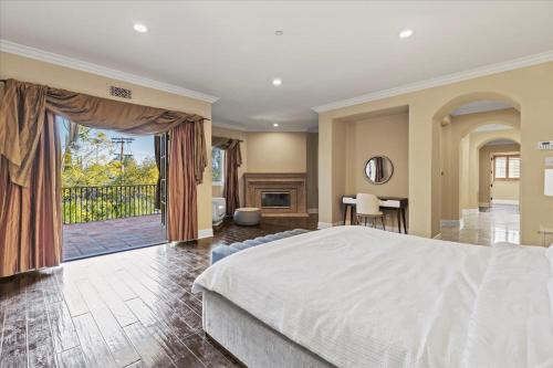 a bedroom with a large bed and a fireplace at 5800 sq ft Gorgeous Tarzana 7 bedroom 9 bathroom home with pool and hot tub in Tarzana