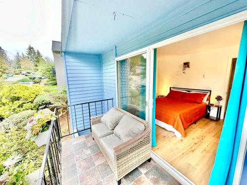 a bedroom on a balcony with a bed and a chair at Elegant Townhome Retreat in Lynnwood in Lynnwood