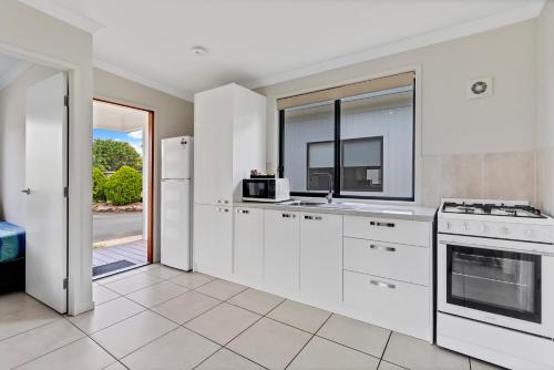 a kitchen with white appliances and a large window at Yandina Caravan Park in Yandina