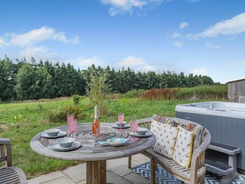 a table and chairs on a patio with a tub at Old Highwood - Piggy In The Middle in Luppitt