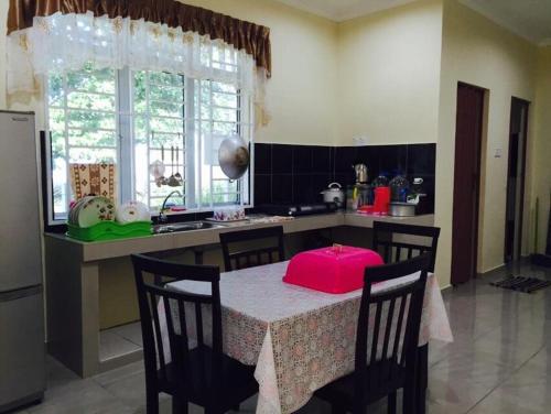 a kitchen with a table with a pink box on it at D'Pantai Homestay Kuala Sg. Baru in Melaka