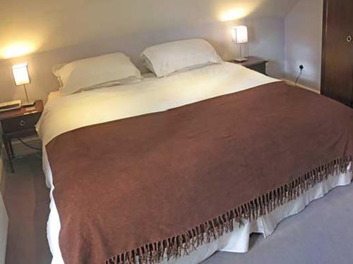 a large bed in a bedroom with two lamps at Tick Tock Cottage in Baslow
