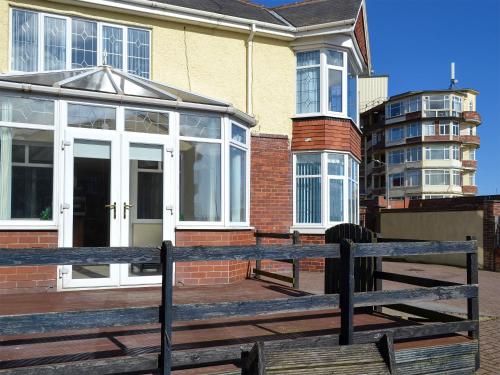 a wooden bench sitting in front of a house at Fisherman's Friend - Uk30742 in Bridlington