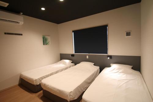 阿蘇市にあるグランドヒルズAsoの薄型テレビ付きの部屋にベッドが2つあります