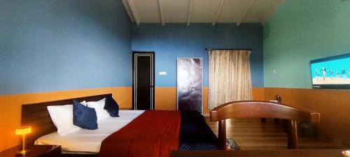 a bedroom with a bed and a flat screen tv at Aasara Homestay Bhimtal in Bhīm Tāl