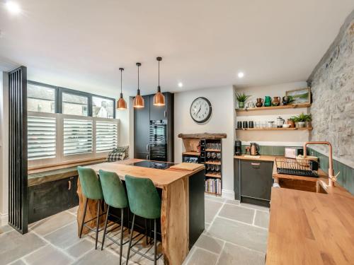 a kitchen with a wooden table and green chairs at Verona House in Tideswell
