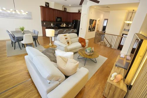 a living room with a white couch and a dining room at Shop, Soak &Sleep Galleria 3BR Retreat Private Jacuzzi in Houston