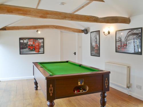 a room with a pool table and pictures on the wall at Burfields Barn in Rickinghall
