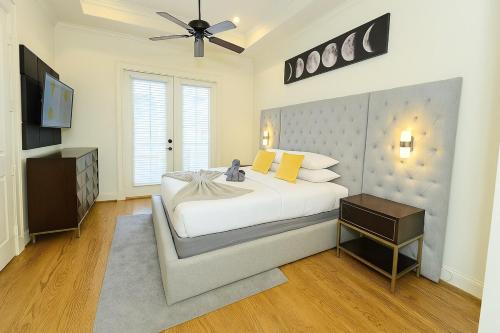 a bedroom with a large white bed and a television at Shop, Soak &Sleep Galleria 3BR Retreat Private Jacuzzi in Houston