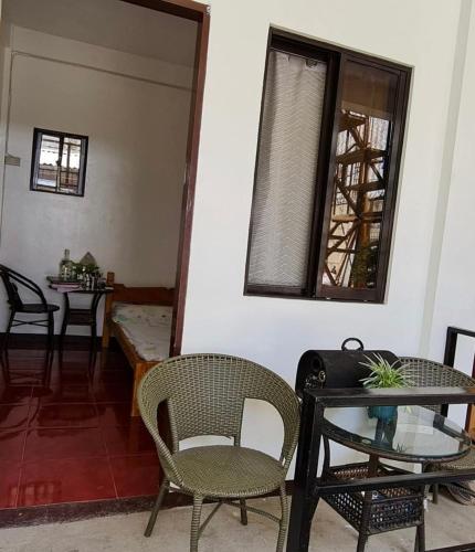 ein Wohnzimmer mit Stühlen und einem Tisch und einem Fenster in der Unterkunft Lei and Eric bed and breakfast in Coron