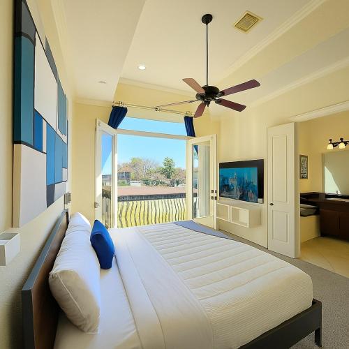 a bedroom with a large bed with a ceiling fan at Galleria Comfort 3BR King Bed Private Jacuzzi and Garage in Houston