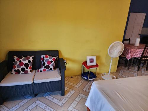 a room with a couch and a yellow wall at sleeps 7 plus private parking apartment near Yallahs in St Thomas Jamaica 