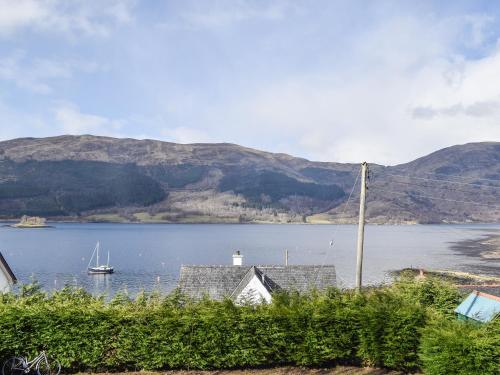 a view of a lake with a house and a boat at Quarter Deck Gardens in Glencoe