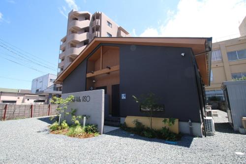 a building with a black wall in front of a building at グランドヒルズAso in Aso