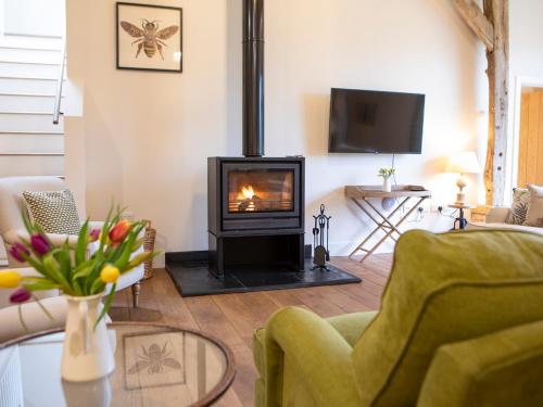 a living room with a wood burning stove in it at Olivers Barn - Uk42081 in East Garston