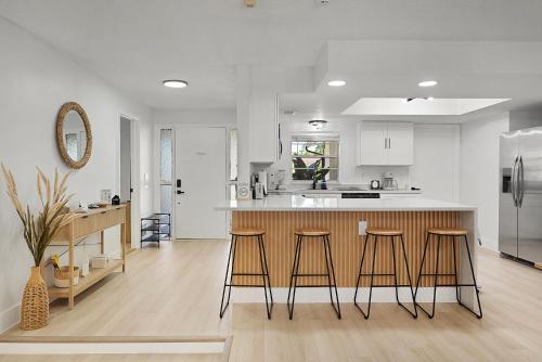 a kitchen with a counter and some stools in it at Relaxing Coastal POOL Home 10 min to the Beach Pets stay free in Palm Coast