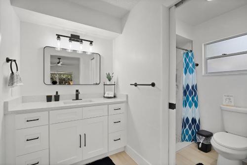a white bathroom with a sink and a toilet at Relaxing Coastal POOL Home 10 min to the Beach Pets stay free in Palm Coast