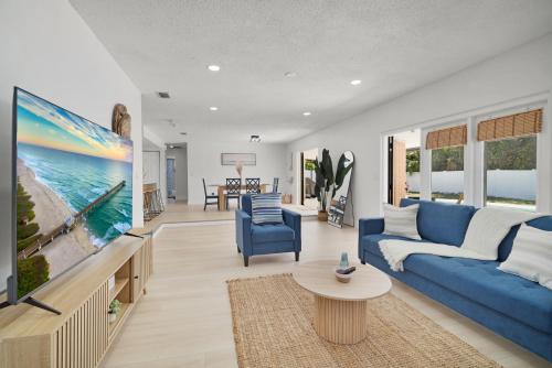 a living room with a blue couch and a tv at Relaxing Coastal POOL Home 10 min to the Beach Pets stay free in Palm Coast