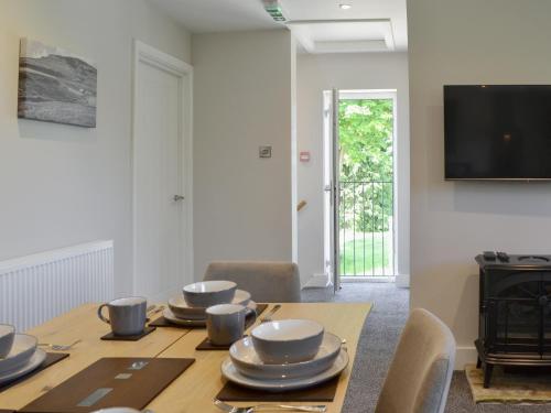 a dining room with a table and a television at Kestrel View in Skipton