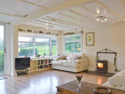 a living room with a white couch and a fireplace at The Summer House in Easthope