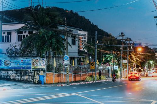 a street with a building and a car on the road at Nyonya Maison Boutique Hotel Phuket Old Town in Phuket Town