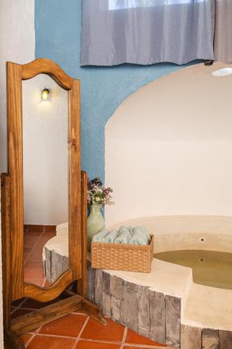 a mirror in a room with a table and a bed at La Ilusión Hotel Campestre y Balneario in Parras de la Fuente
