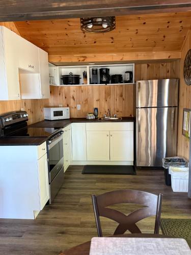 a kitchen with white appliances and wooden walls at Cloverleaf Cottages in Oxtongue Lake