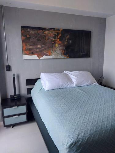 a bedroom with a bed and a painting on the wall at New apartment in Yu Country GDL view 22nd floor in Guadalajara