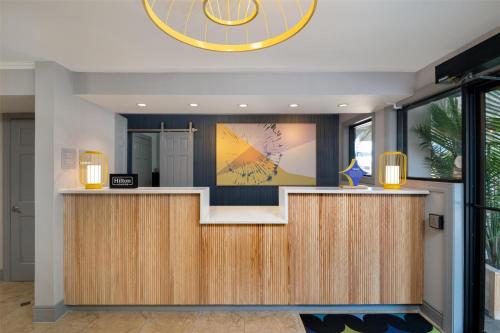 a lobby with a reception desk with a large clock at Spark by Hilton Chincoteague Island in Chincoteague