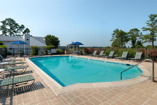 a large swimming pool with chairs and a gazebo at Spark by Hilton Chincoteague Island in Chincoteague
