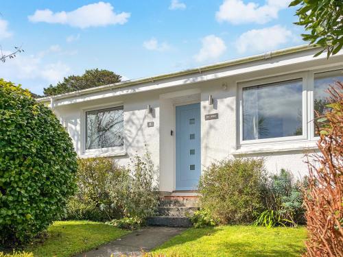 a white house with a blue door at The Lodge in Fowey