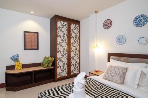 a bedroom with a bed and a table and a window at Nyonya Maison Boutique Hotel Phuket Old Town in Phuket Town