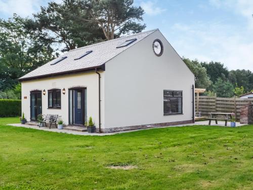 un cottage bianco con un orologio sul tetto di Heatherdene - Fern Cottage a Wilberfoss