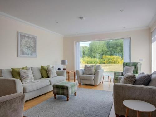 a living room with couches and chairs and a large window at Darna House in Tain