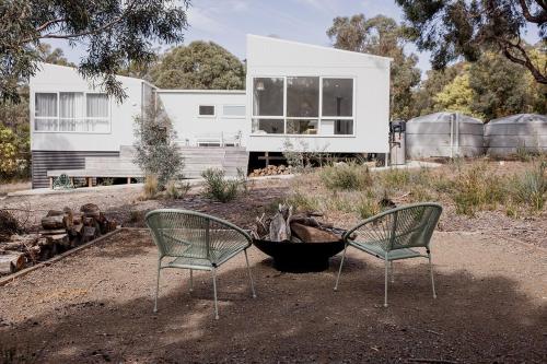 two chairs sitting in front of a house at Spring Beach Rise in Spring Beach