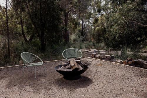 two chairs and a plant in a pot in a yard at Spring Beach Rise in Spring Beach