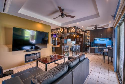 a living room with a couch and a large screen tv at Hacienda Iguana Luxury Apartment with Pool & Golf in Tola