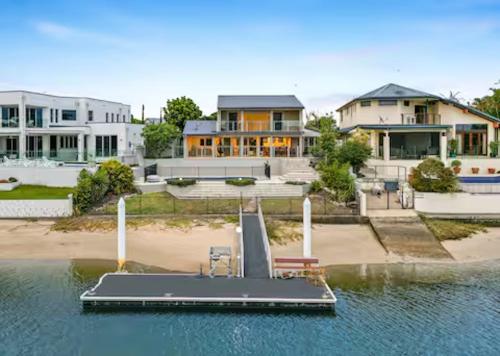 a dock in the water in front of a house at Sorrento Waterfront Retreat & Pool in Gold Coast