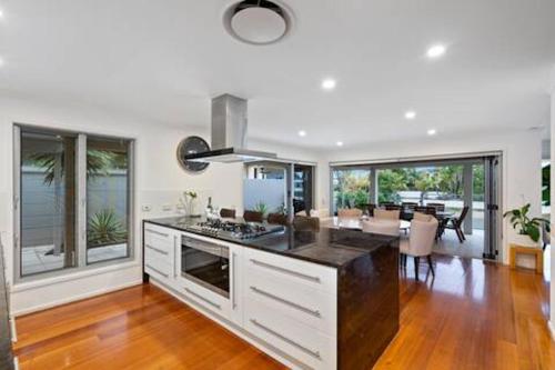 a kitchen with a stove and a dining room at Sorrento Waterfront Retreat & Pool in Gold Coast